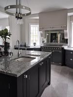 Modern kitchen with marble worktop on large black island 