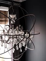 Detail of modern chandelier and black painted walls 