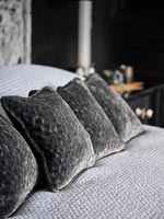 Row of grey cushions on bed - detail 