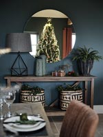 Reflection of Christmas tree in round dining room mirror 