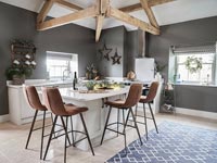 Barstools around modern kitchen island - decorated for Christmas 