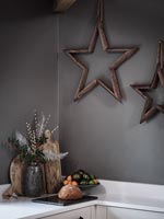 Wooden star decorations on grey painted modern kitchen wall 
