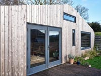 Exterior of small modern cabin with tiny decking area 