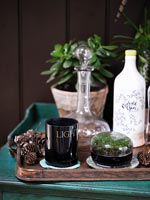 Pinecones on wooden tray with glass decanter 