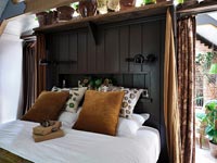 Black painted panelled wall in country bedroom 