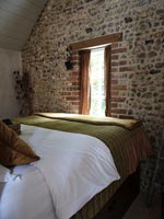 Exposed stone wall in country bedroom 