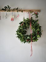 Christmas wreath and decorations on wooden coat hook
