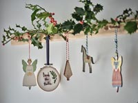 Holly and Christmas decorations on wooden coat hook
