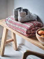 Cosy slipper boots on blanket next to bowl of fruit 