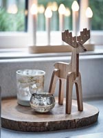 Carved wooden reindeer next to tealight holders - detail 