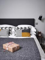 Wrapped gifts on bed in modern bedroom 