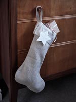White Christmas stocking on wooden chest of drawers - detail 