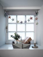 Grey painted wooden trug and star bunting on windowsill