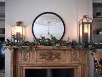 Garland on wooden mantelpiece in country living room at Christmas time