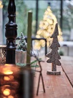 Small carved Christmas tree on wooden dining table 