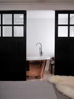 Copper freestanding bath in modern en-suite bathroom 
