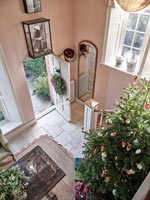 Overhead view of modern hallway with open front door and Christmas tree 