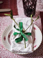 Decorative mistletoe and ribbon on serviette
