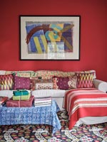 Patterned cushions on sofa in colourful eclectic living room 