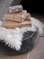 Wrapped Christmas presents on grey pouffe 