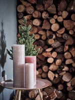 Group of pink candles next to miniature Christmas tree