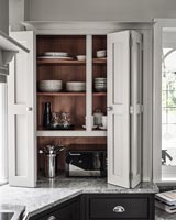 Modern kitchen unit - open cupboard doors revealing crockery storage 