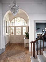 Large entrance hall with view of front door with stained glass windows 