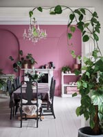 View into dining room with pink painted walls and white floor