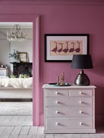 White chest of drawers against pink painted wall 
