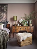Wooden crate as a seat next to antique dressing table 