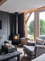 Lit wood burning stove in modern living room decorated for Christmas 