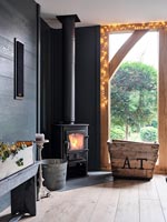 Lit wood burning stove in modern living room decorated for Christmas 