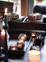 Detail of wrapped gifts and candles on coffee table 