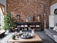 Christmas tree against exposed brick wall in modern living room