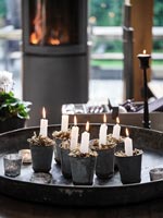 Lit candles in tiny pots on metal tray 