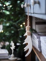 White antler ornaments hanging from sideboard drawer 