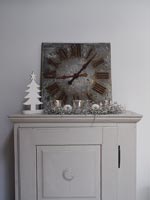 Clock on small cabinet with Christmas decorations 