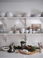 Christmas decorations on modern white kitchen worktop and shelving 