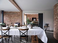 Table cloth on dining table in modern dining room with exposed brickwork 