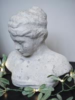 Stone bust of a young woman decorated with fairy lights 