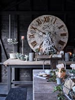 Large clock, Christmas decorations and candles on wooden table 