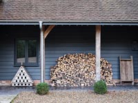 Large woodpile on covered terrace of country house 