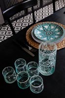 Decorative blue glass and plate on black dining table 