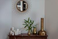 Gold mirror above small fireplace 