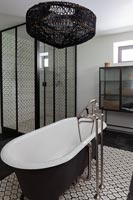Modern monochrome bathroom with freestanding bath in centre 