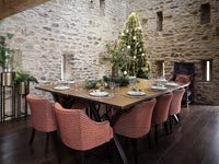 Country dining room with exposed stone walls decorated for Christmas 
