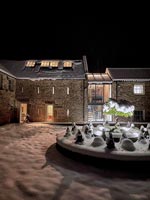 Exterior of country house covered in snow at night 