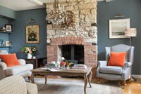 Country living room with exposed stone chimney breast 