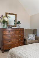 Wooden chest of drawers in country bedroom 
