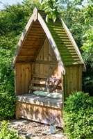 Decorative wooden arbour seat in country garden 